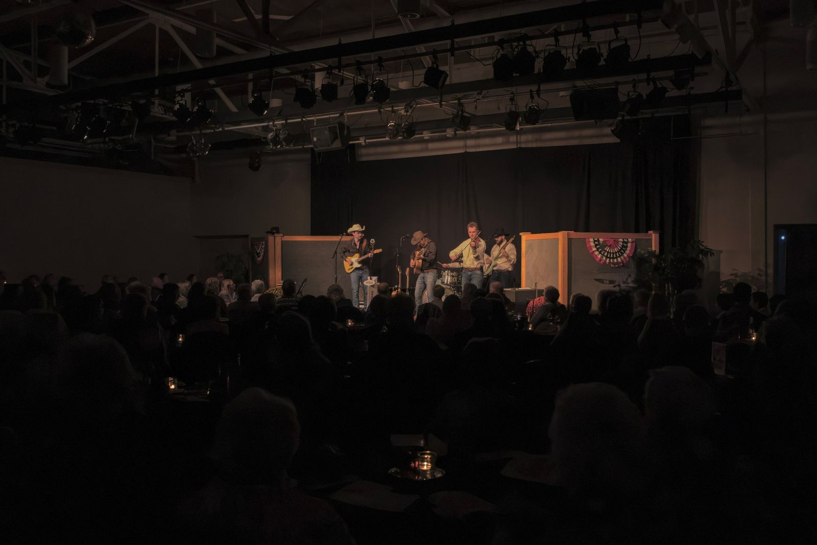 A full house watching the band on a lit stage